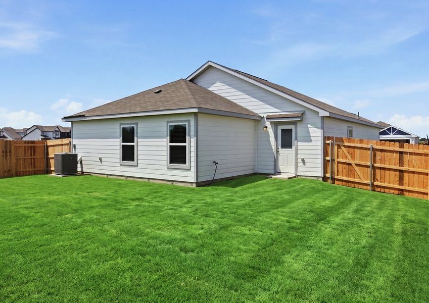 Rear exterior of the single-story Frio floor plan featuring a privacy-fenced backyard and grassy lawn. Rear exterior of the single-story Frio floor plan featuring a privacy-fenced backyard and grassy lawn.