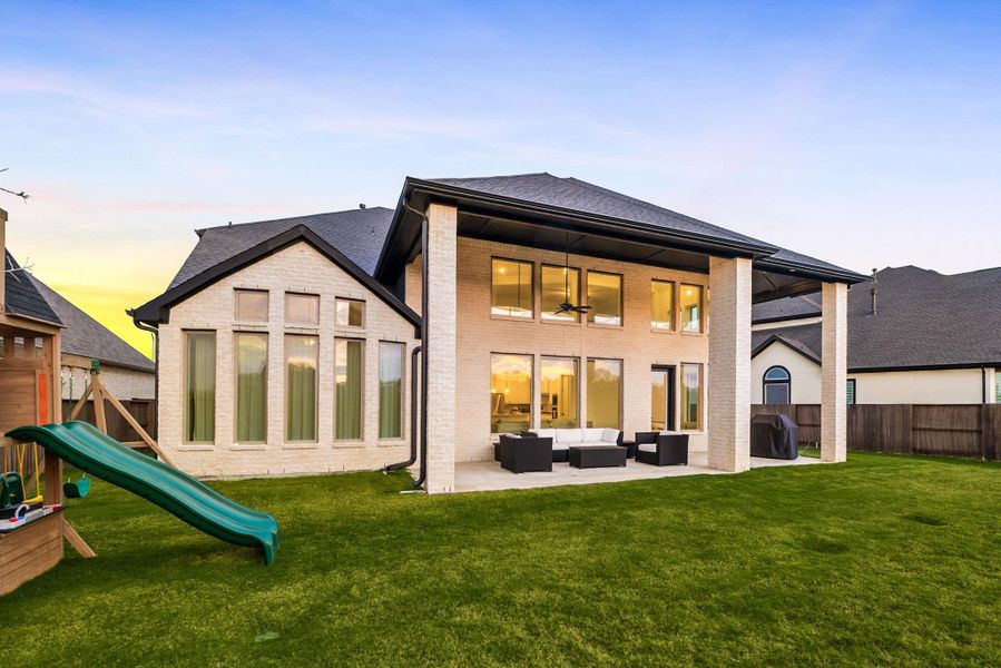 The rear exterior highlights the covered patio and open backyard, offering plenty of outdoor space.