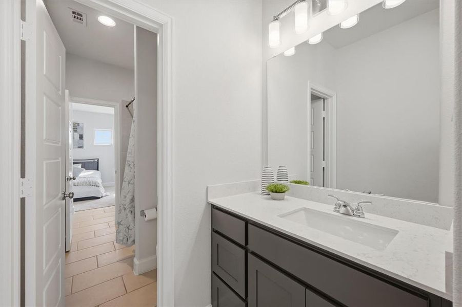 Bathroom with vanity, light tile patterned flooring, and connected bathroom