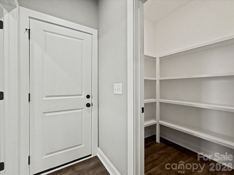 Spacious walk-in pantry with built-in shelving provides exceptional storage and organization for all your kitchen essentials.