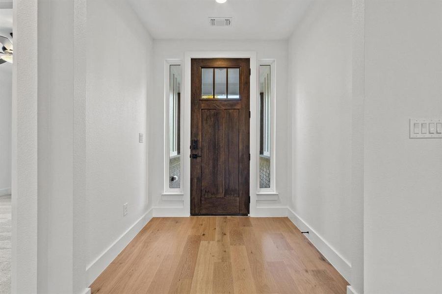 Foyer entrance featuring light wood-style floors and baseboards