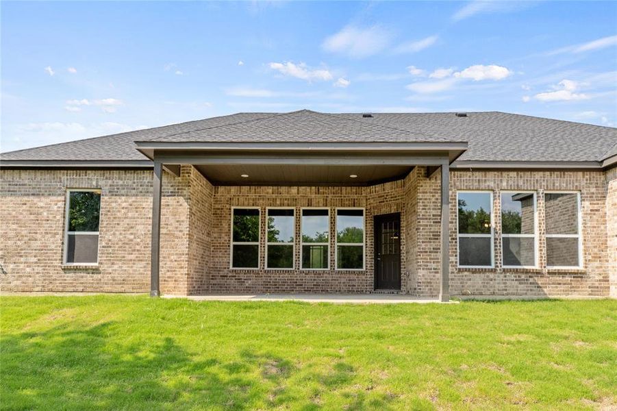 Rear view of property featuring a patio area and a lawn