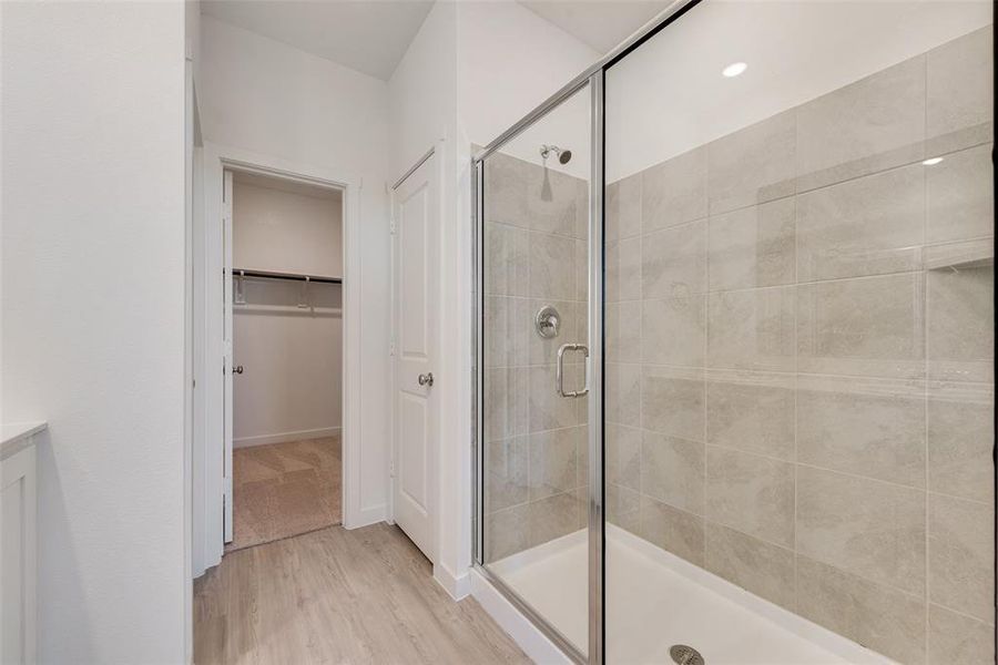 Bathroom featuring wood-type flooring, vanity, and walk in shower