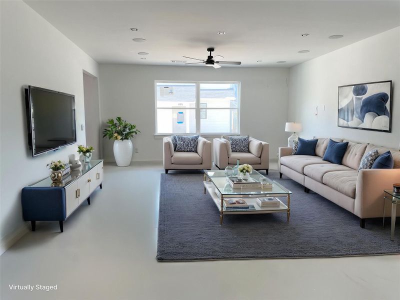 Living room featuring a ceiling fan, finished concrete floors, and recessed lighting