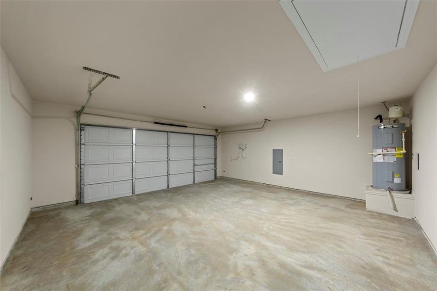 Two-car garage featuring a sectional overhead door, concrete flooring, recessed lighting, and a ceiling access panel