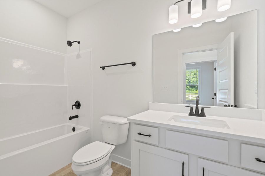 White vanity with a rectangular undermount sink, white countertop, and matte black fixtures White vanity with a rectangular undermount sink, white countertop, and matte black fixtures