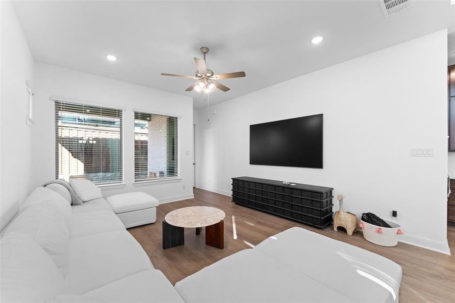 Living room with recessed lighting, a ceiling fan, and wood finished floors Living room with recessed lighting, a ceiling fan, and wood finished floors