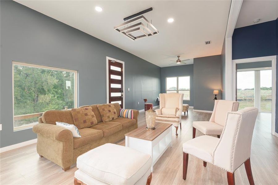 Living room with ceiling fan, light wood-type flooring, and recessed lighting Living room with ceiling fan, light wood-type flooring, and recessed lighting