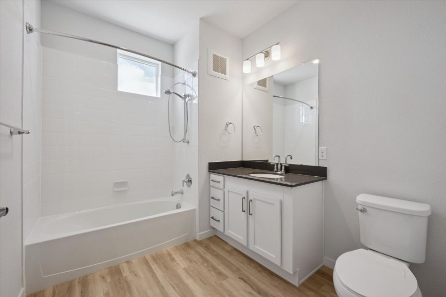 A bathroom with a tub toilet and sink. A bathroom with a tub toilet and sink.
