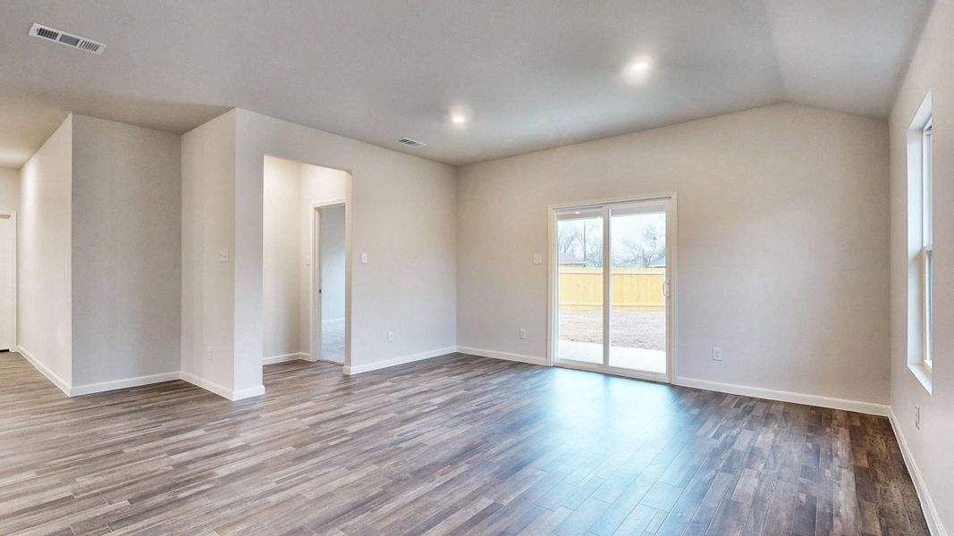 A room with a wood floor and a wood floor with a door.