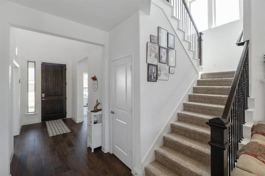 Foyer entrance featuring stairs, dark wood finished floors, and baseboards