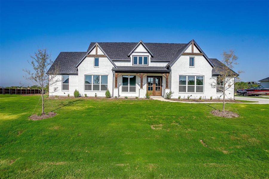 View of front of property with a front yard and covered porch