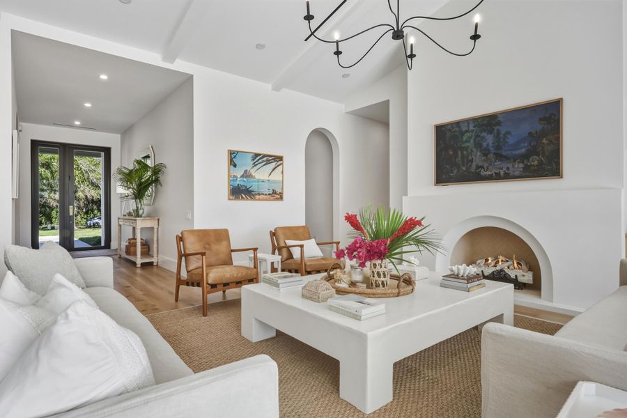 Formal living room is oversized with custom coffee table to fit the space & arched isokern fireplace with herringbone detail