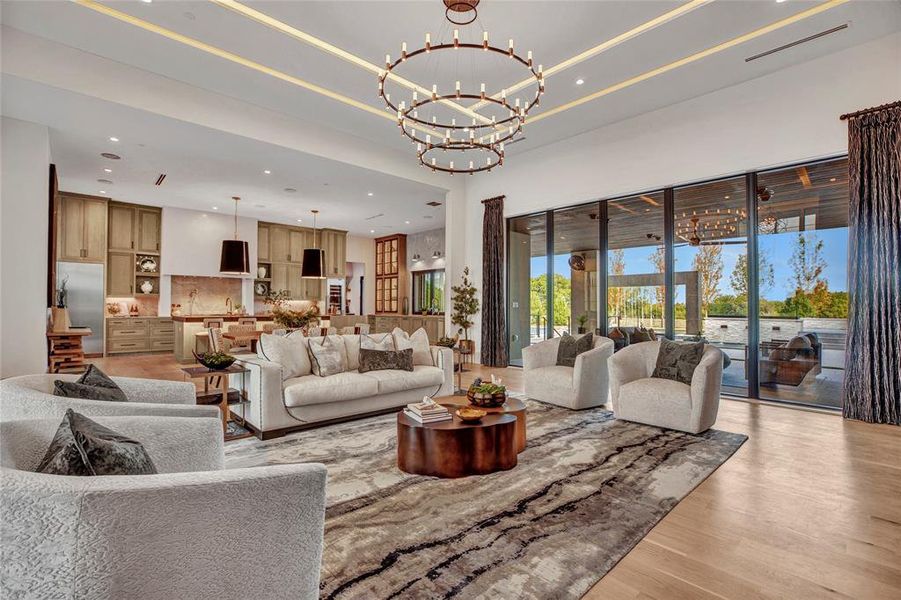 Living area with recessed lighting, light wood-style flooring, and a chandelier Living area with recessed lighting, light wood-style flooring, and a chandelier