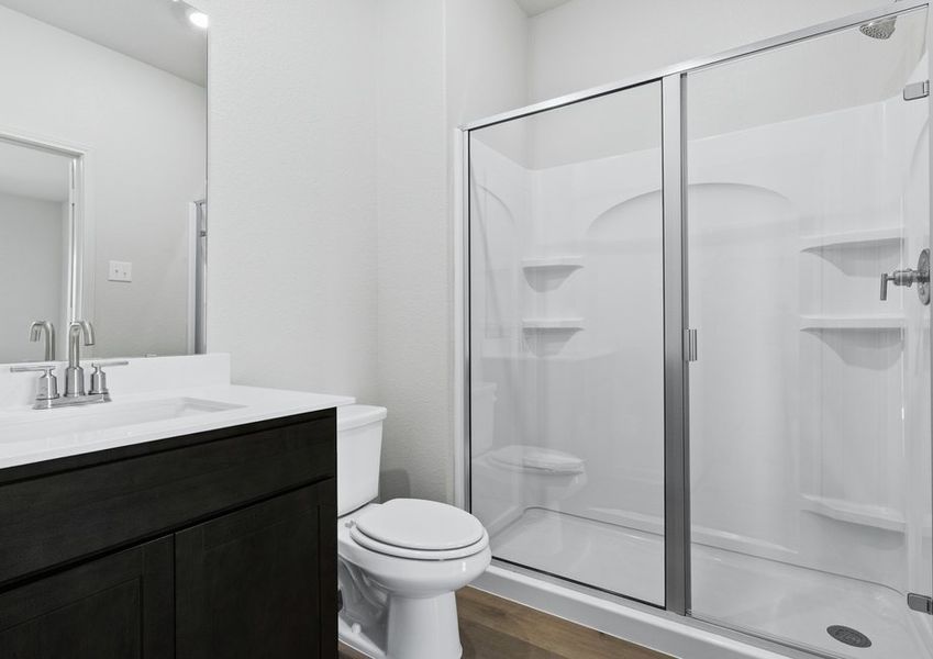 The master bathroom has a sprawling vanity and glass walk-in shower.