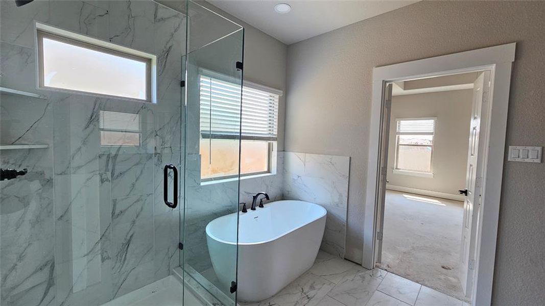 Bathroom featuring shower with separate bathtub and tile patterned floors