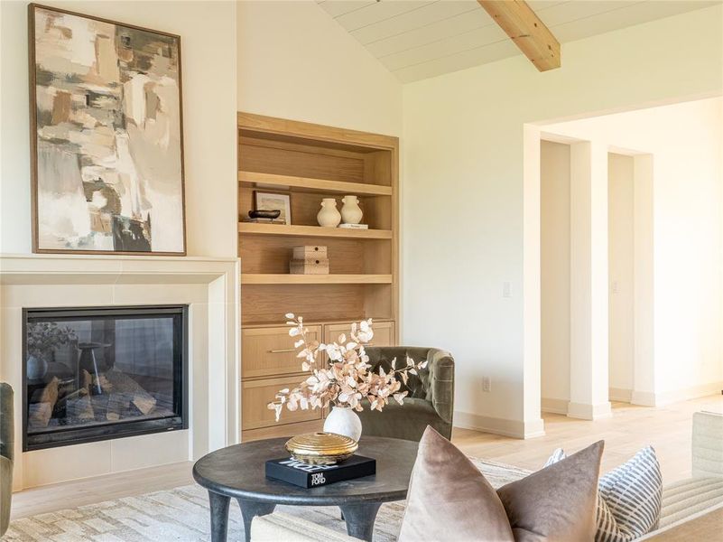 Living area with light wood-type flooring, a glass covered fireplace, built in features, and wooden ceiling