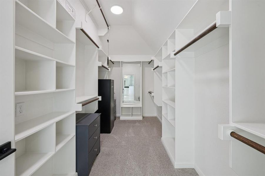 Spacious closet with lofted ceiling and light colored carpet Spacious closet with lofted ceiling and light colored carpet