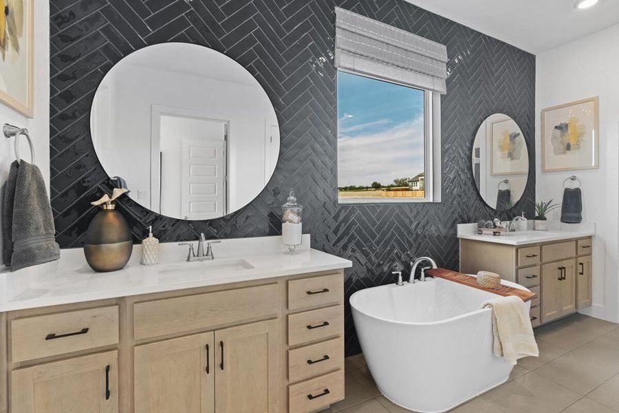 Bathroom with a soaking tub, two vanities, and light tile patterned flooring