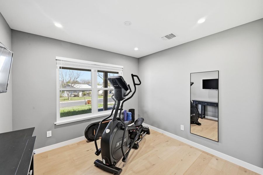Workout room featuring light wood finished floors and recessed lighting