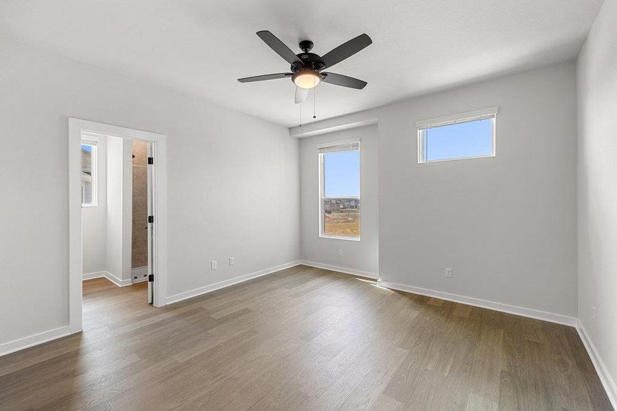 Empty room with light wood finished floors and ceiling fan