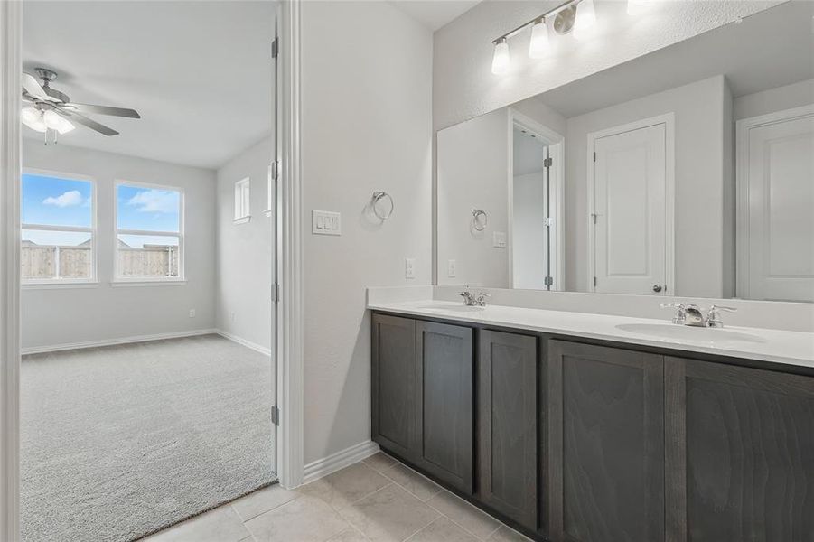 Full bath featuring double vanity, ceiling fan, and tile patterned flooring Full bath featuring double vanity, ceiling fan, and tile patterned flooring