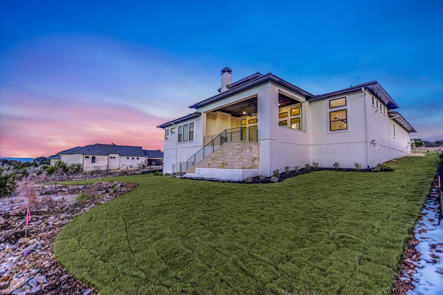 View of home's exterior featuring a chimney, a yard, stucco siding, and a ceiling fan