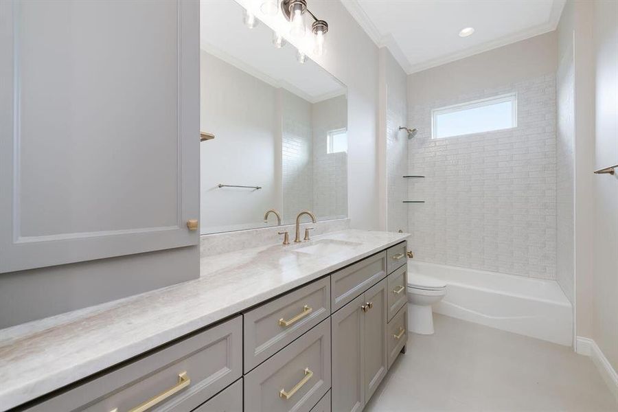 Full bath featuring vanity, shower / tub combination, and ornamental molding Full bath featuring vanity, shower / tub combination, and ornamental molding
