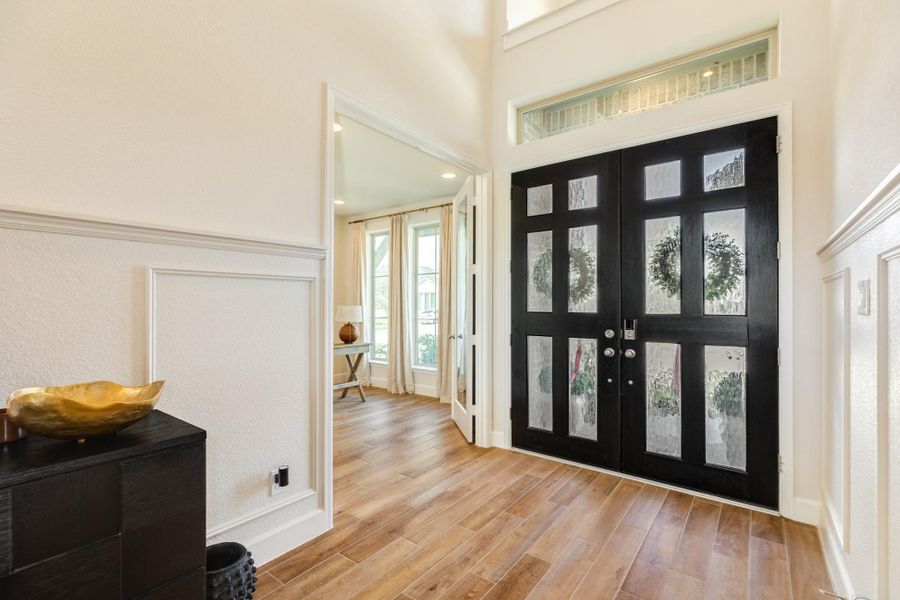 Upon entry, you are greeted by astonishing tile flooring that offers a warm, wooden aesthetic. The foyer features soaring ceilings with tall windows positioned above the front door, allowing an abundance of natural light to flood the space, while a dedicated office is conveniently situated to your right. Upon entry, you are greeted by astonishing tile flooring that offers a warm, wooden aesthetic. The foyer features soaring ceilings with tall windows positioned above the front door, allowing an abundance of natural light to flood the space, while a dedicated office is conveniently situated to your right.