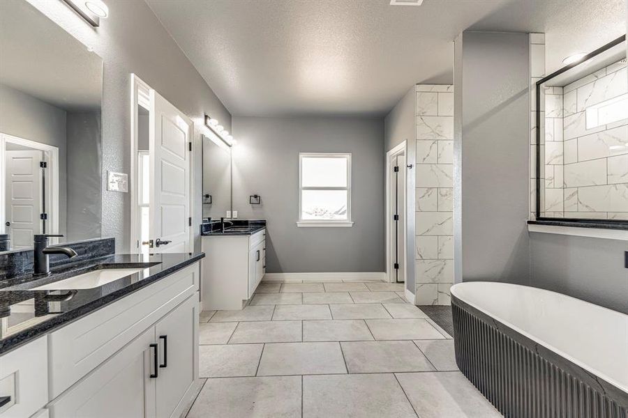 Bathroom featuring tile patterned floors, a washtub, a textured ceiling, and vanity