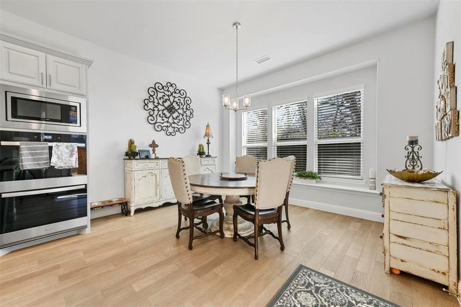 Dining area featuring light hardwood / wood-style floors and a notable chandelier