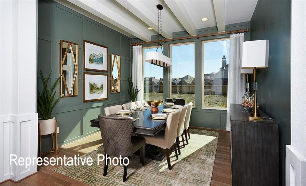 Dining area featuring wood-finish flooring, a coffered ceiling, and a prominent paneled accent wall Dining area featuring wood-finish flooring, a coffered ceiling, and a prominent paneled accent wall