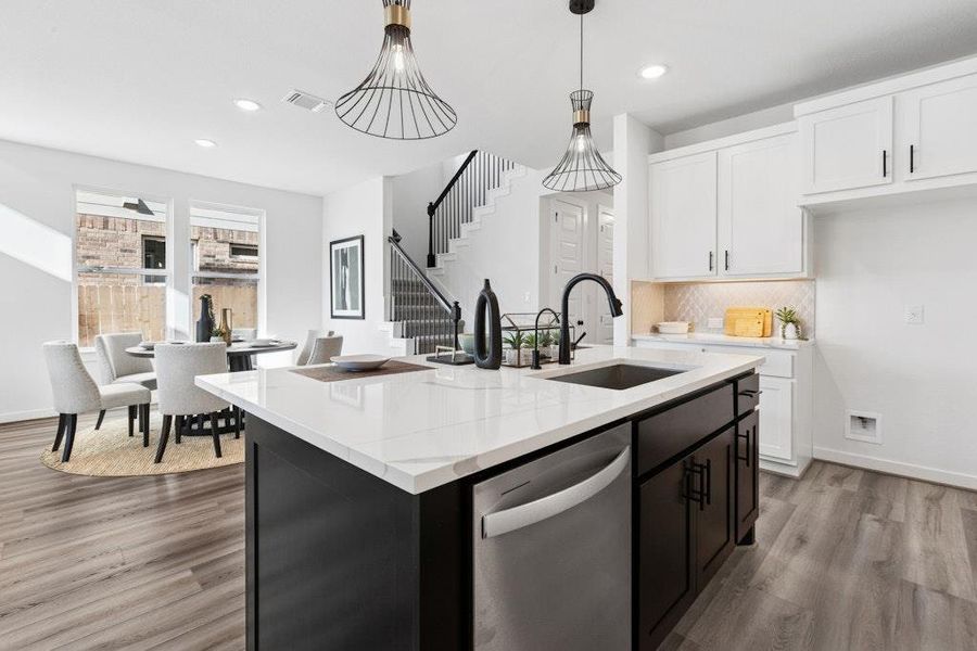 Kitchen featuring dark cabinets, white cabinets, dishwasher, light wood finished floors, and a center island with sink Kitchen featuring dark cabinets, white cabinets, dishwasher, light wood finished floors, and a center island with sink
