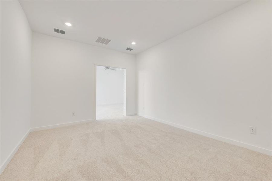 Spare room featuring light carpet and ceiling fan