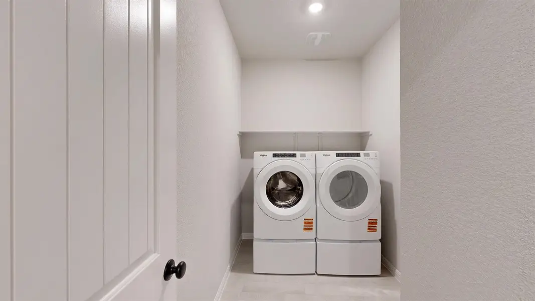 Laundry area with a textured wall and washer and clothes dryer