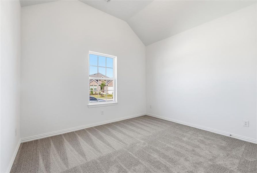 Vaulted ceiling room featuring a single-pane window with grids, light gray carpet, white walls, and white baseboards