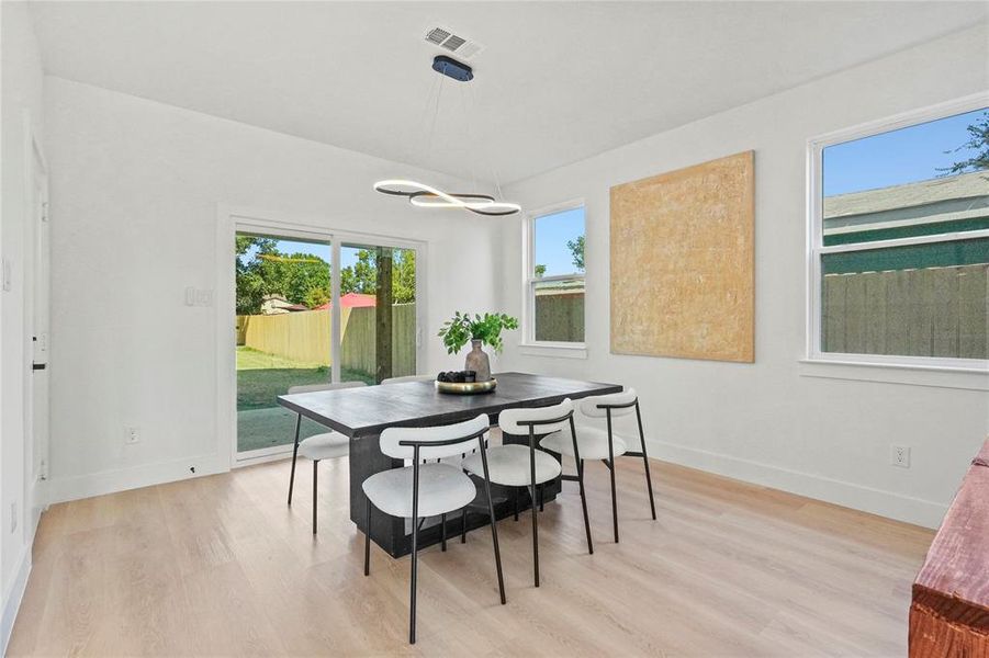 Dining space featuring plenty of natural light and light wood-style floors Dining space featuring plenty of natural light and light wood-style floors
