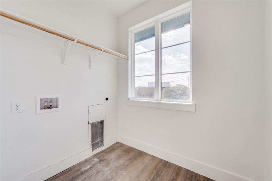 Washroom with plenty of natural light, hookup for an electric dryer, wood-type flooring, and hookup for a washing machine