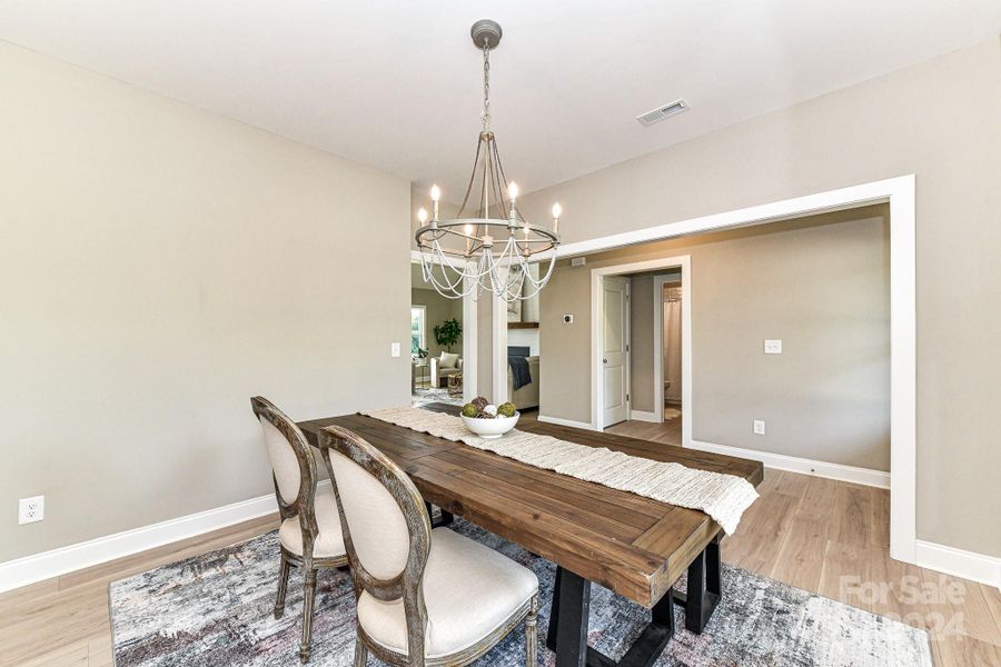 Formal Dining Room features custom light fixture & LVP floors!