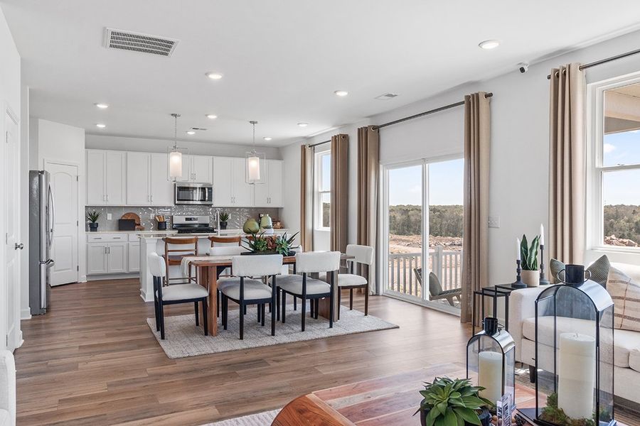 A kitchen with a dining table and chairs.