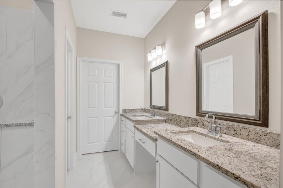 Primary bath features double sinks, vanity and oversized shower. Primary has 2 walk in closets - so no sharing here!