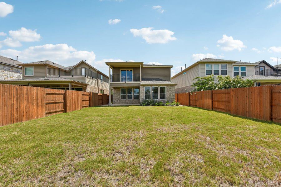 A private, fenced backyard offers ample green space for outdoor activities and relaxation.