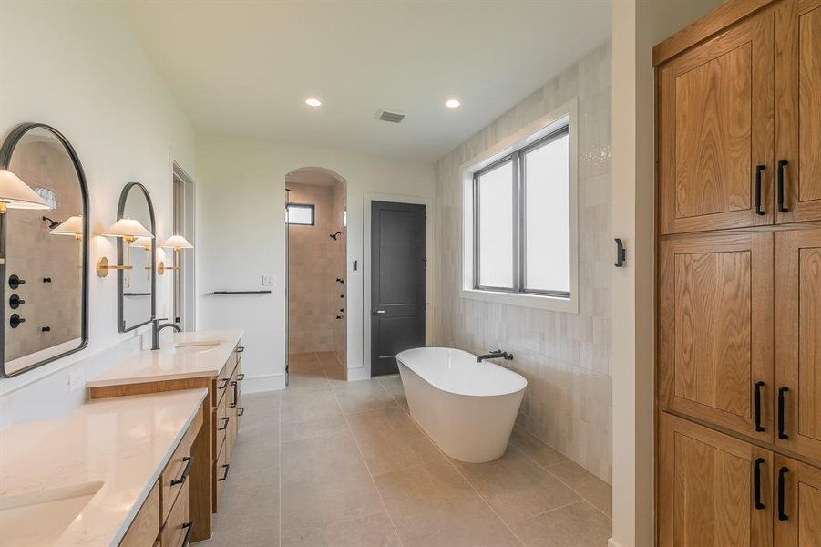 Full bath with a soaking tub, double vanity, a walk in shower, light tile patterned flooring, and recessed lighting