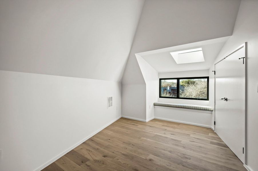 Third floor bedroom with lofted ceiling, custom upholstered bench and skylight Third floor bedroom with lofted ceiling, custom upholstered bench and skylight