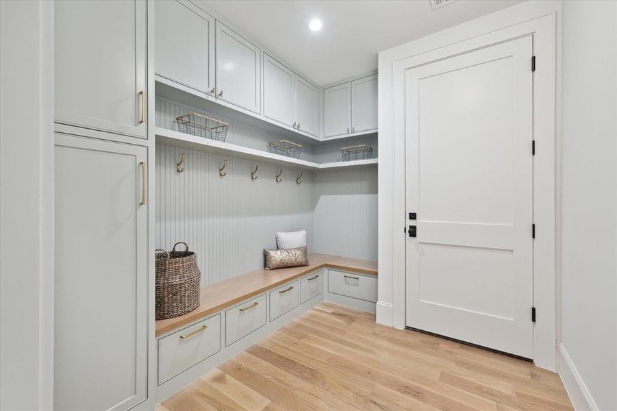 The Mudroom is located off the garage entry and offers ample storage and custom cabinetry with white oak bench top.