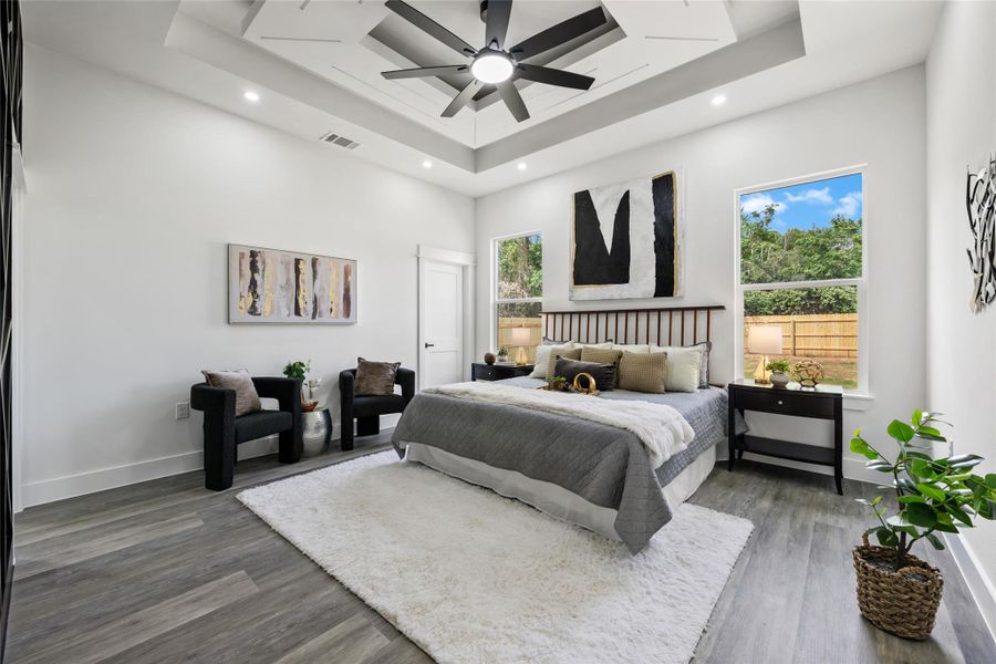 Spacious room featuring a tiered tray ceiling with recessed lighting and a ceiling fan