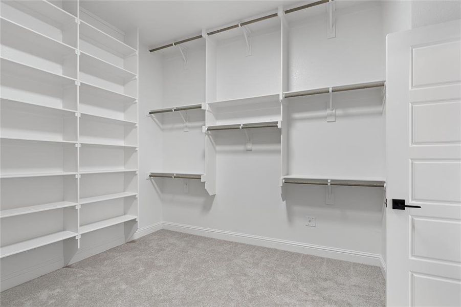 Spacious closet with light colored carpet