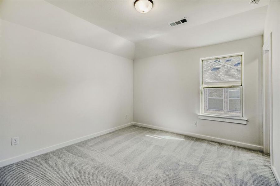 Unfurnished room with light carpet and lofted ceiling
