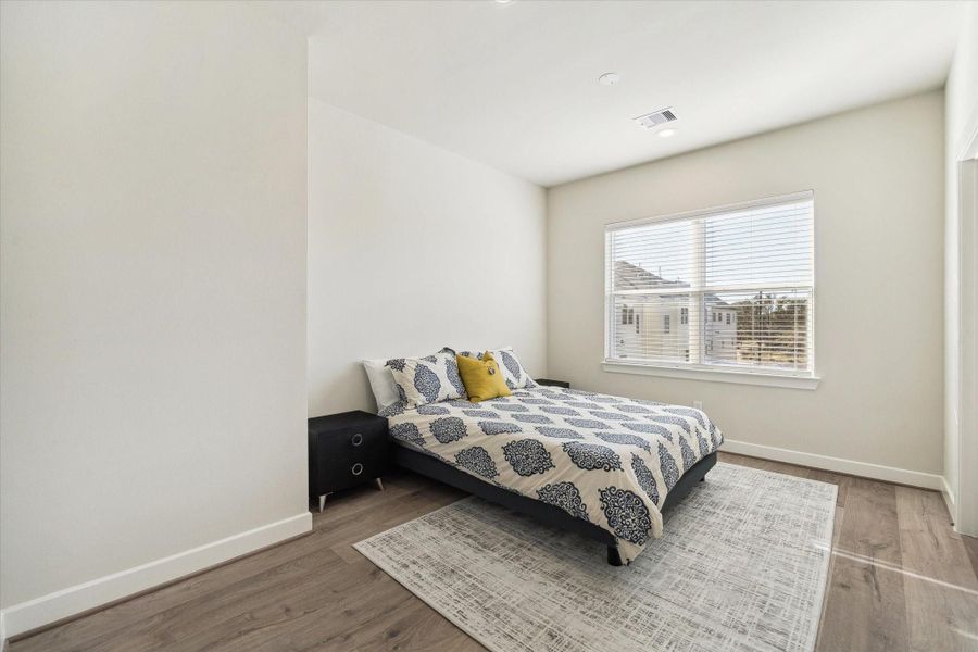 Large windows bring in natural light, creating a comfortable and inviting bedroom space.