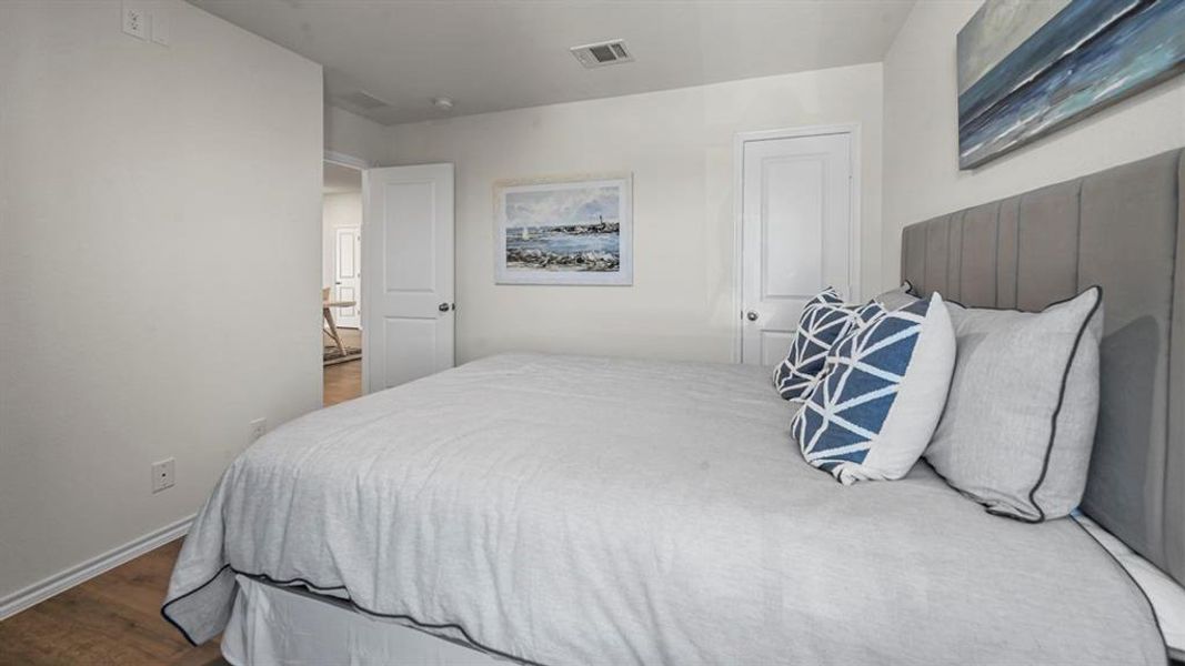 Bedroom featuring dark wood-style flooring and baseboards
